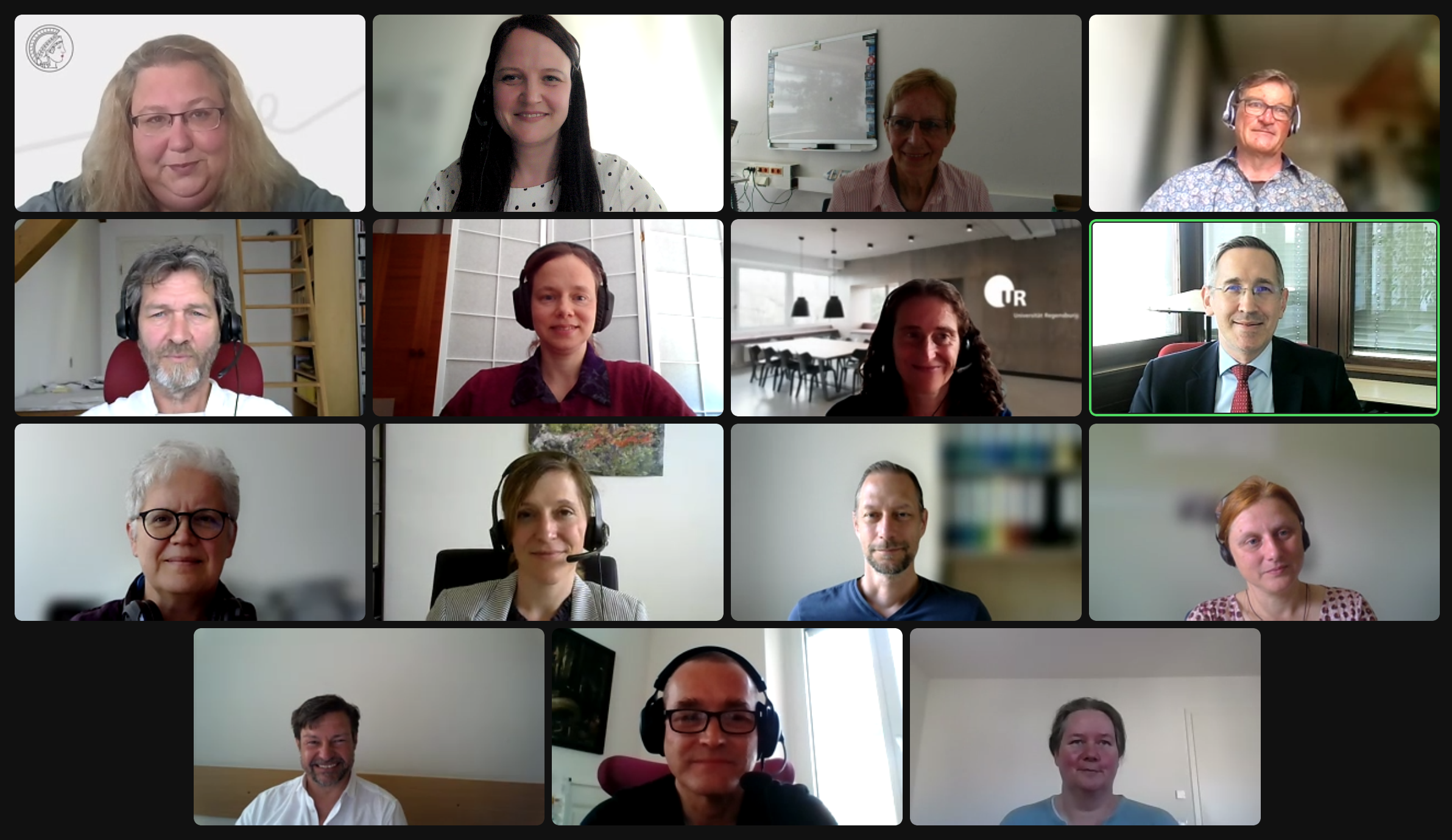 A screenshot of a zoom conference in a professional context. 15 white middle-aged people, about half with glasses, smile into the camera.